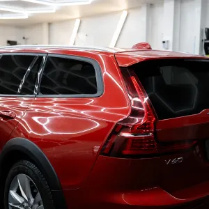 Röd Volvo V60 med tonade rutor och solfilm hos FTF Solfilm i Stockholm