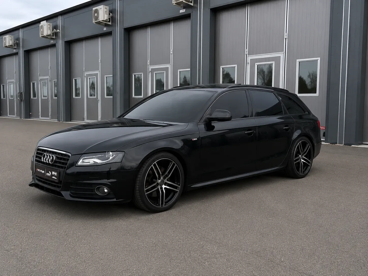 Svart Audi A4 med tonade rutor efter professionell toning med solfilm utanför verkstad i Skövde.
