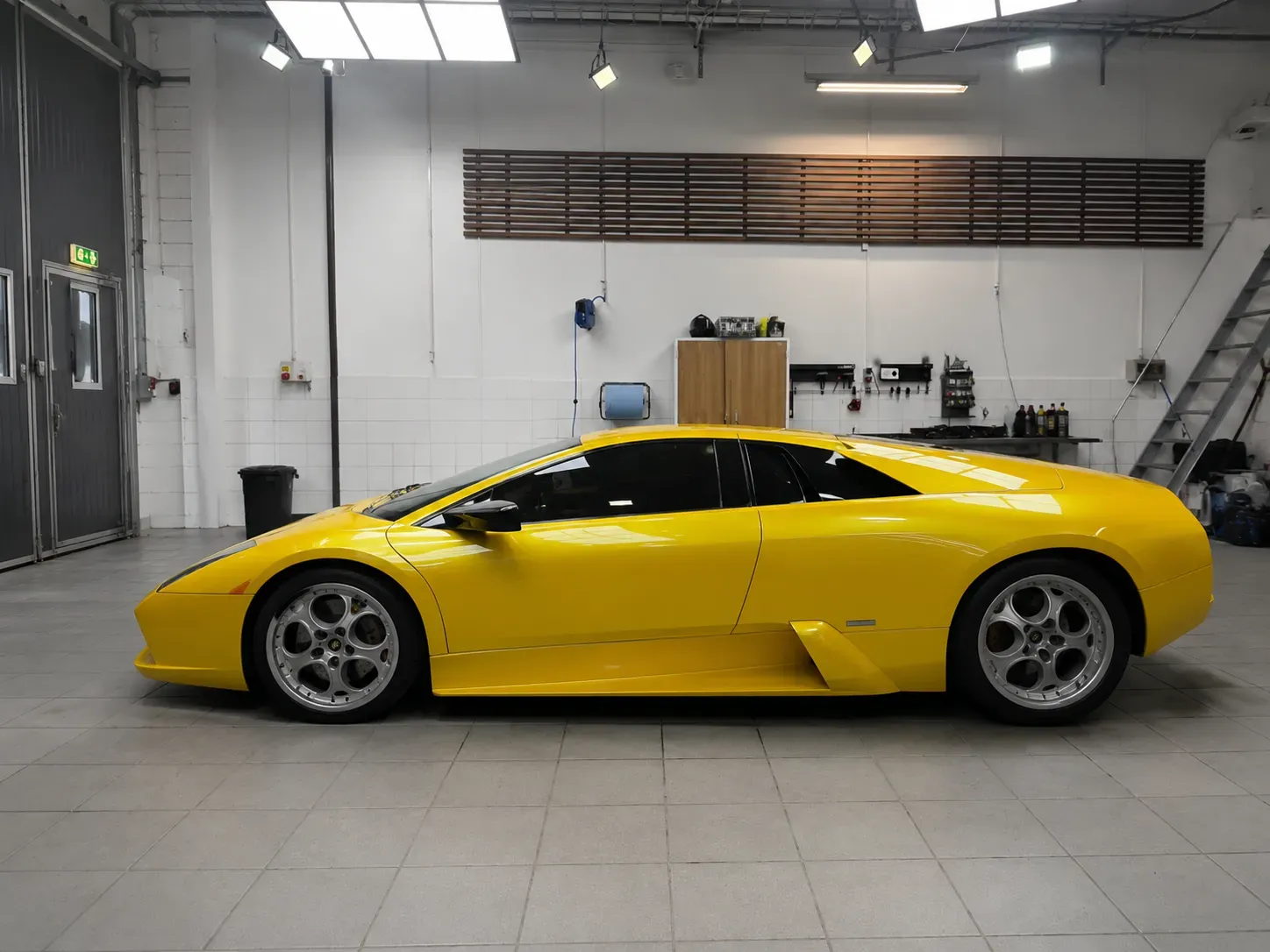Gul Lamborghini Murciélago med tonade rutor efter professionell toning med solfilm inne i verkstad i Skövde.