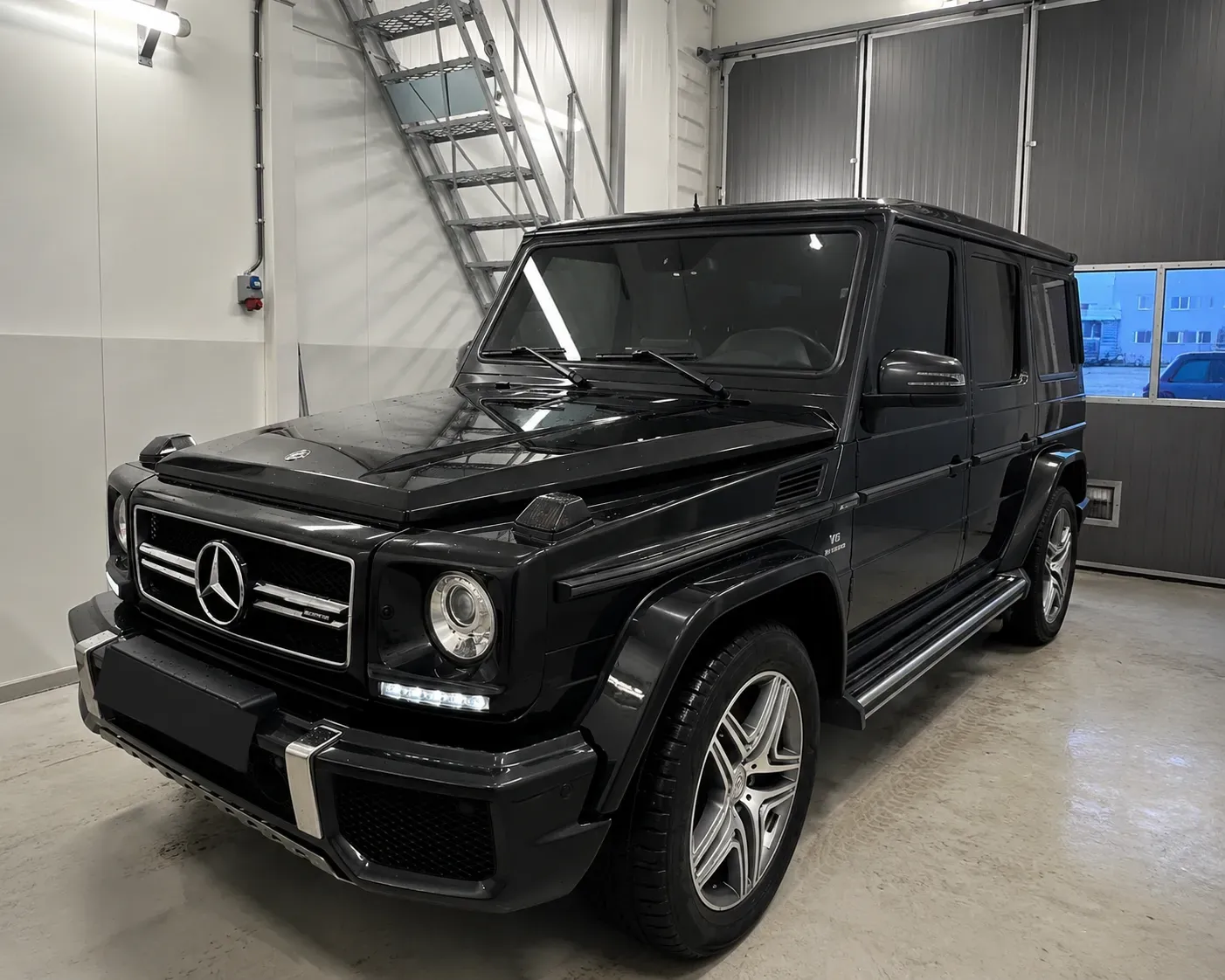 Svart Mercedes G Klass med tonade rutor efter professionell toning med solfilm inne i verkstad i Skövde.