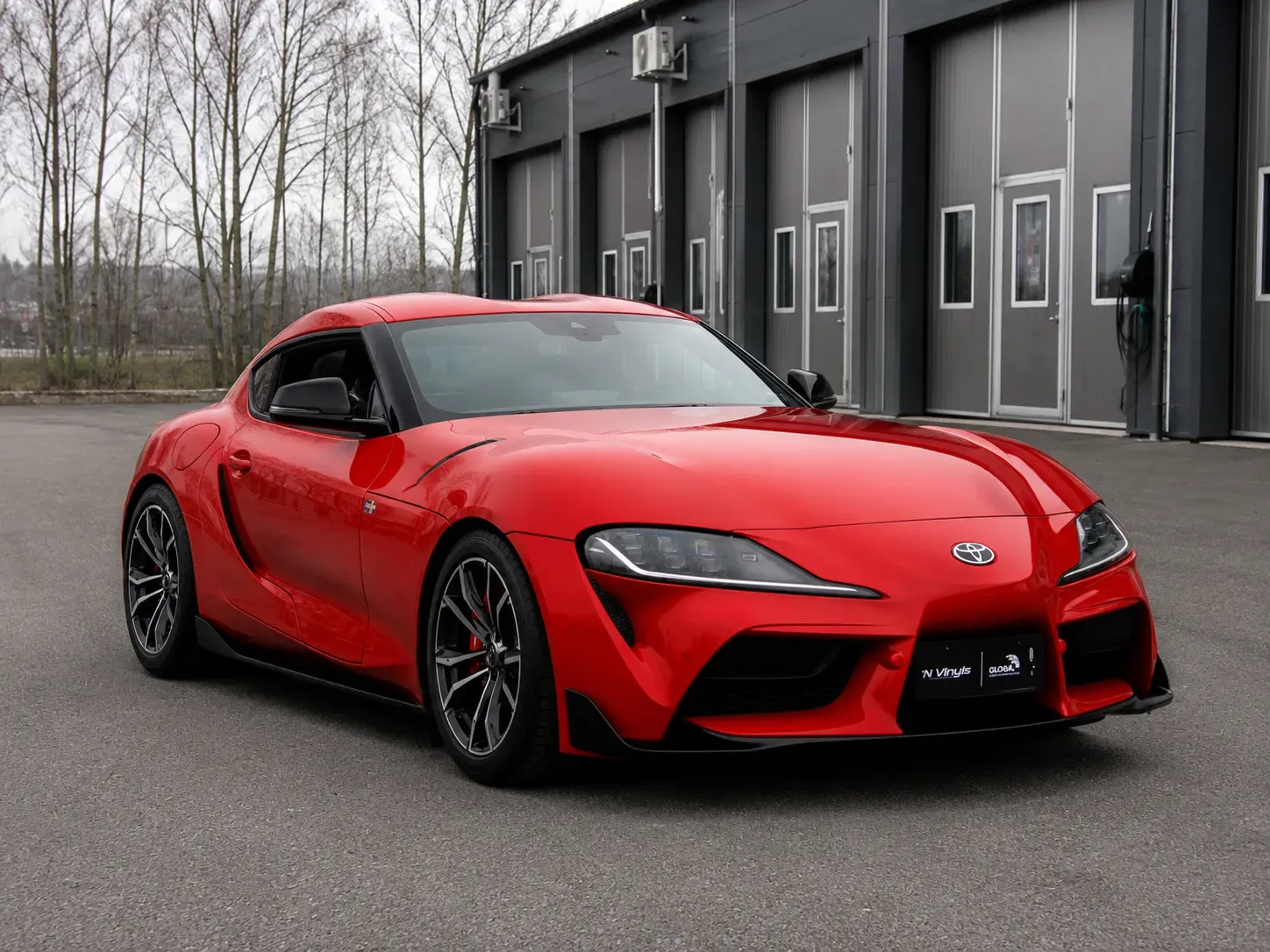 Röd Toyota Supra med tonade rutor efter professionell toning med solfilm utanför verkstad i Skövde.