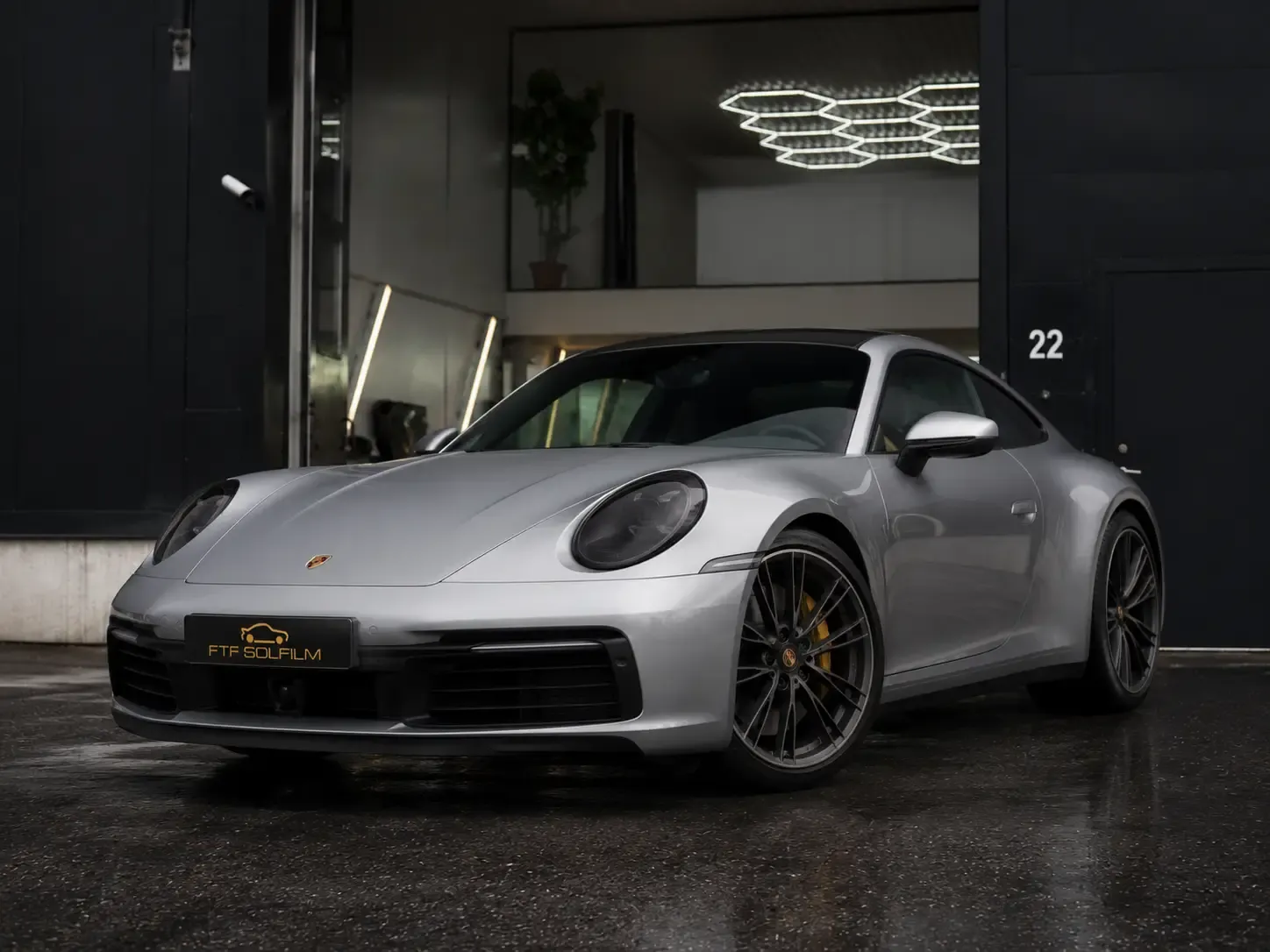 Silverfärgad Porsche med tonade lyktor hos FTF Solfilm i Haninge, Stockholm.