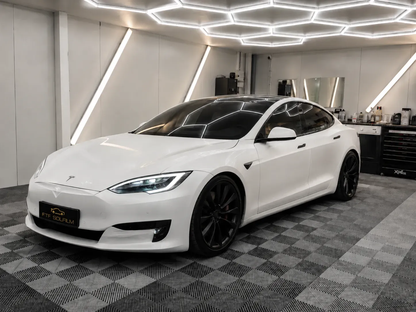 Vit Tesla med tonade rutor i FTF Solfilms verkstad i Stockholm