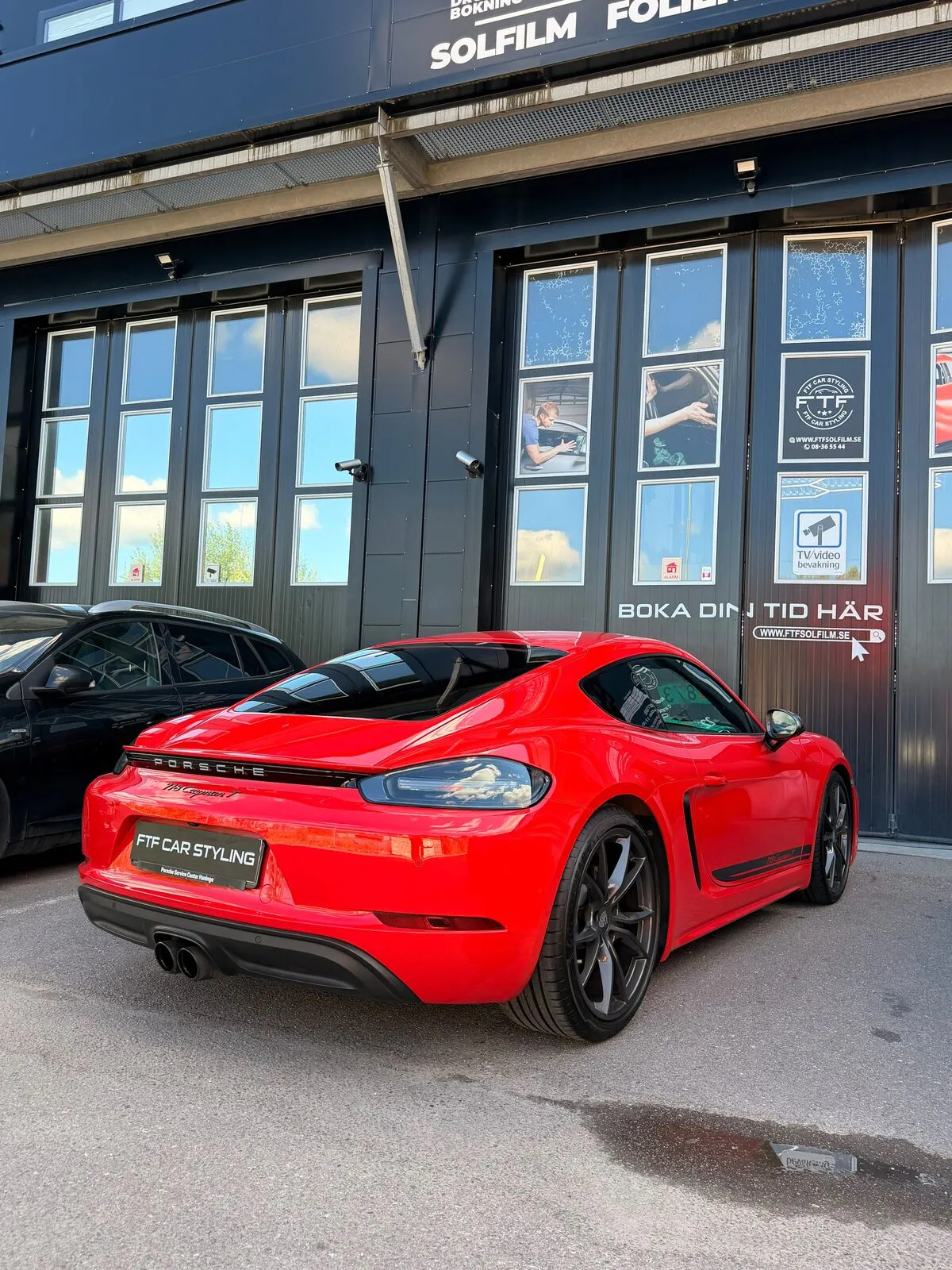 Röd Porsche framför FTF Solfilms verkstad i Jordbro med skyltar för solfilm och folie