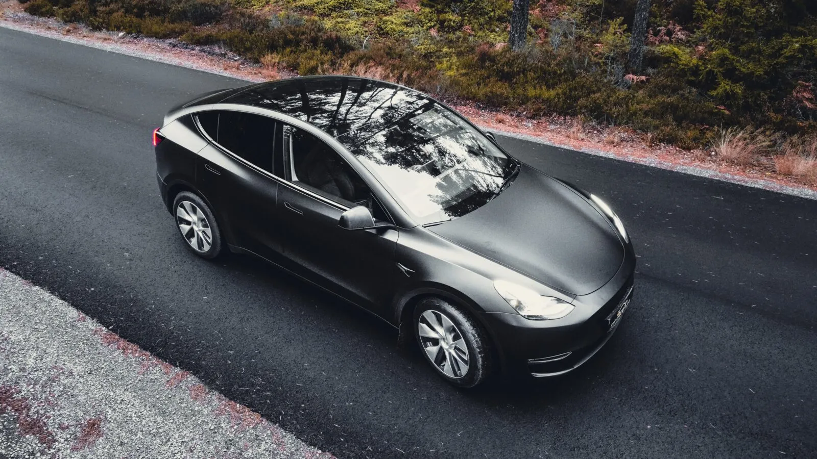 Tesla Model Y i matt grå finish på en landsväg
