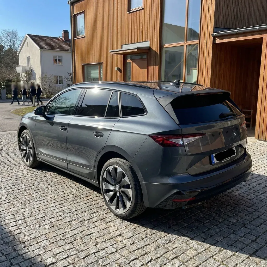 Elegant modern bil med tonade rutor parkerad på solig gata i Bromma