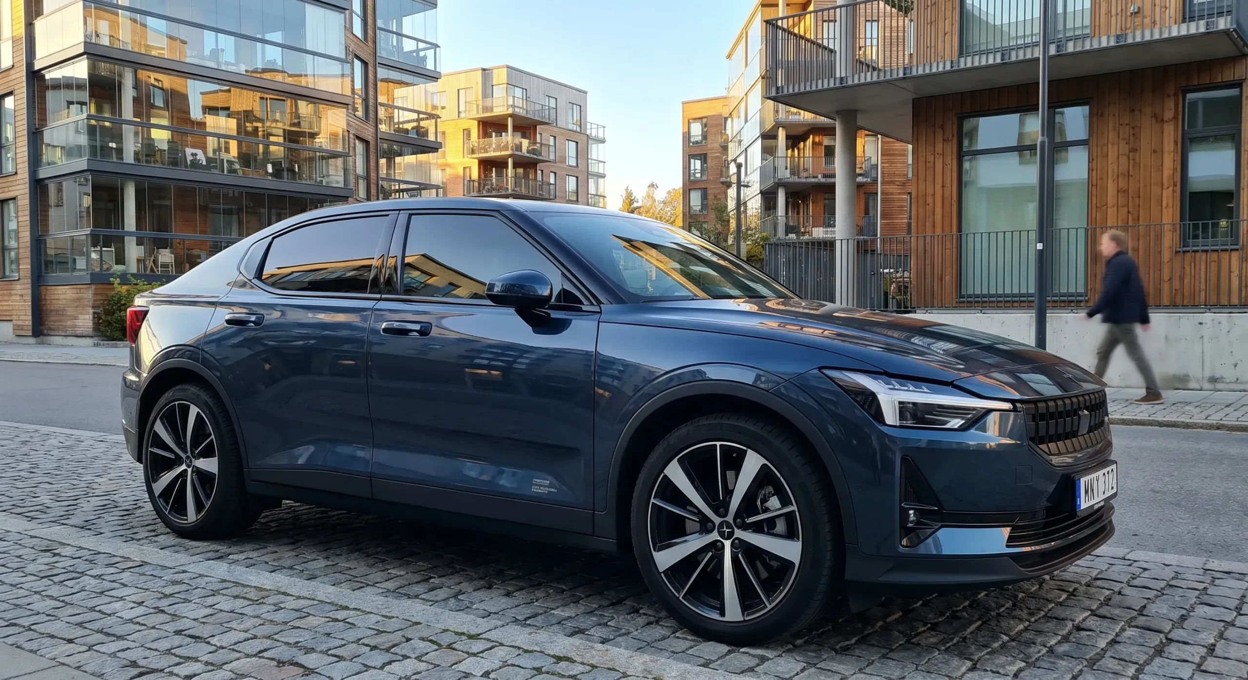 Volvo XC90 med tonade rutor parkerad på solig Stockholmsgata.